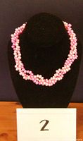 Image of three-strand twisted pink freshwater pearl necklace displayed on a black bust showing the overall twisted multi-strand design.