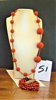 Front display of cinnamon-coloured beaded necklace and bracelet on a white bust and flat surface, showing the size and design of beaded spheres on necklace and bracelet pile.