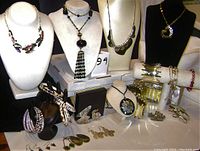Overview photo showing the full assortment of necklaces, bracelets including animal print designs, brooches, and earrings displayed on busts and stands.