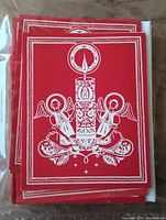 Stack of red and white vintage Christmas cards designed in Folk-Baroque style showing a candle and angels on the cover.