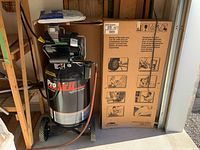 Front view of black Pro Air II compressor next to boxed packaging