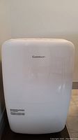 Front view of the white Garrison dehumidifier with smooth plastic housing and brand name on front.