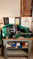 Full view of green bench lathe model B244 mounted on gray steel stand