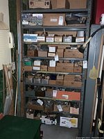 Full metal shelf with nine levels holding boxes and containers of assorted hardware items