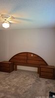 Wide shot showing headboard and two attached nightstands in a bedroom setting.