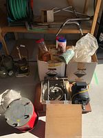 Full view of lot showing rock polisher components and two boxes containing accessories, with various jars and supplies visible.