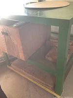 Underside view of heavy metal rolling bench showing sturdy frame, wheels and blocks underneath