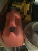 Red plastic jerry can next to yellow power tools