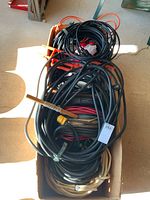 Two boxes filled with assorted electrical wires and heavy duty extension cords tangled and coiled inside with labelled indicators