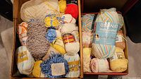 Two boxes of assorted cotton yarn including Bernat Handcrafter and other brands in various colors.