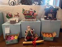 Four ceramic Christmas candle holders and accompanying holiday votive candles on boxes