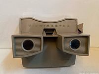 Front close-up of gray View-Master viewer showing lenses and lever