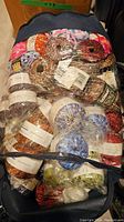 Large collection of yarn skeins packed in a bag showing various brands and colors