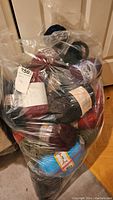 Bag full of assorted yarn skeins in different colors and brands.