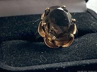 Front view of ring showing oval smokey topaz and gold prong setting