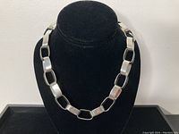 Full necklace on black bust showing overall design.