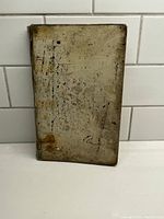 Full view of front cover showing heavily worn and aged book cover with significant staining and discoloration