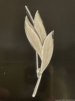 Front view of a sterling silver Mid Century Modern leaf pin with three stylized leaves, signed Bond and Boyd