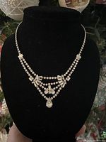 Full view of the sterling silver lavalier necklace on black velvet display, showcasing the double-strand and hanging teardrop stones.