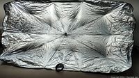 Front view of the sunshade showing silver reflective material and central handle.