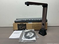 IOCHow S1 document scanner and camera with original box, user manual, USB cable, and black rolled backdrop behind.
