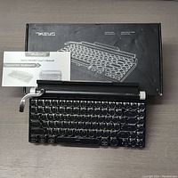 Front view of keyboard with box and user's manual showing the keyboard layout and packaging.