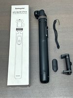 Photo of Sensyne G72 selfie stick alongside its box, detached wireless remote, black wrist strap, and phone holder.