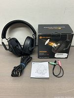 Senzer SG500 headphones with original box, user manual, 3.5mm cable, and Y-splitter adapter with pink and green plugs.