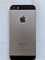 Back view of the Apple iPhone SE showing the Space Gray metal back panel with the Apple logo and SE branding.