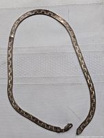 Full view of the silver choker chain laid out flat showing its length and overall design.