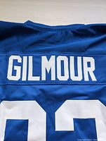 Close-up of sewn white GILMOUR nameplate on blue jersey