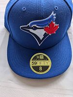 Front view of blue Toronto Blue Jays cap with embroidered logo and 59FIFTY size sticker