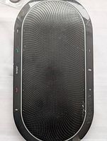 Top view of Jabra Speak 810 speaker showing black perforated grille and touch control buttons.