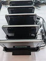 Five Panasonic Toughbook FZ-L1 tablets seated in charging dock on white surface