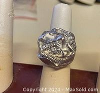 Close-up photo of a 925 sterling silver ring size 8.5 featuring a textured, artistic design with small embedded stones.