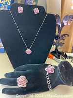 Full set displayed: ring, bracelet, necklace with matching purple crystal rose design on black stand and glove.