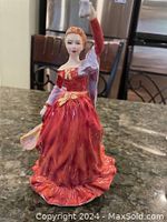 Front view of Royal Doulton porcelain figurine showing woman in red dress holding fan
