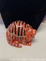 Side view of orange cat trinket box showing crystal accents and zipper hinge.