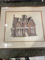 Photo of the framed pen and ink sketch showing the old Victorian-style house artwork, matted and protected under glass.
