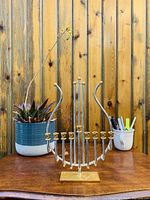 Menorah displayed on a wooden surface with a wood backdrop showing the whole item