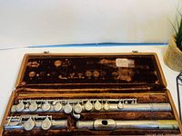 Silver plated flute in three pieces inside plush-lined case.