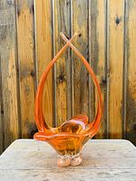 Front view of the vintage Chalet art glass basket with distinctive two tall upward curved handles and flared open basket shape.