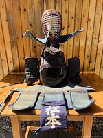 Full set on wooden table: men, do, kote, tare with name tag