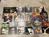 Overview photo showing about 26 CDs laid out on floor including Marilyn Manson and Rammstein albums with colorful and dark cover art