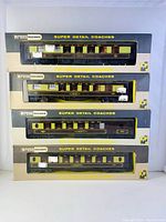 Four Wrenn Super Detail coaches in original Wrenn Railways boxes stacked with clear front windows showing dark green and yellow Pullman coaches