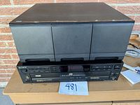 Sony 5-disc CD player unit on a table showing front panel controls and display, with good cosmetic condition and minor surface marks.