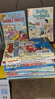 Photo displays a stack of 16 Archie Comics books including Archie, Jughead, Betty, and Veronica themed Double Digest magazines with colorful covers.