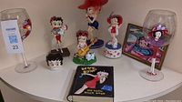 Wide view of the collection showing all Betty Boop figurines, stem glasses, and metal book figurine