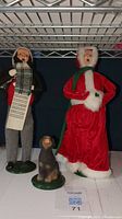 Full view of the two Byers Choice caroler figurines and the dog figurine on a shelf.
