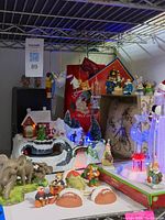 Wide view of the shelf with Christmas village, light-up reindeer, Santa figurines, and hanging ornaments.
